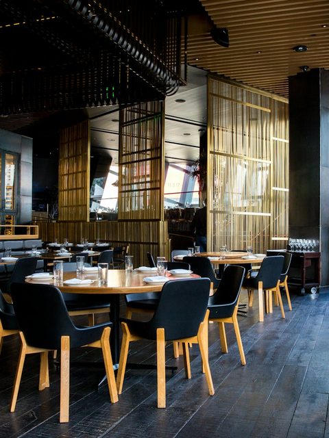 A warmly lit restaurant dining room set for evening service.