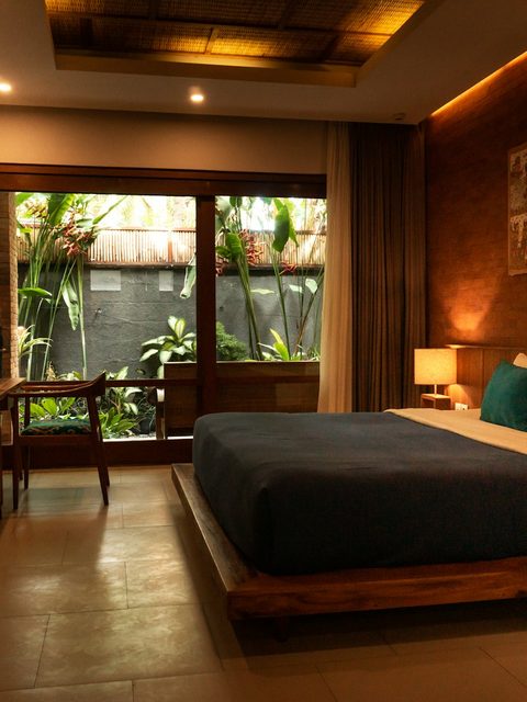 A contemporary hotel suite with a made bed, soft lighting and a calm stay atmosphere.